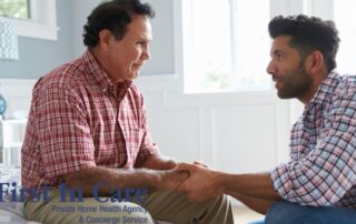 A daughter who is caregiving for her dad who has Alzheimer’s disease, lovingly holds his hands.