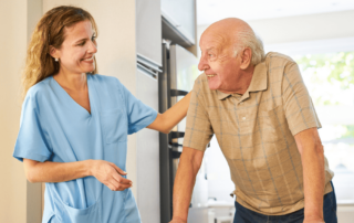 Caregiver smiling at senior man using a walker