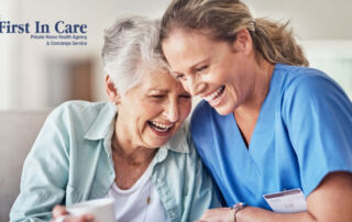 A woman who is providing companion care and her senior client laugh and enjoy their time together.