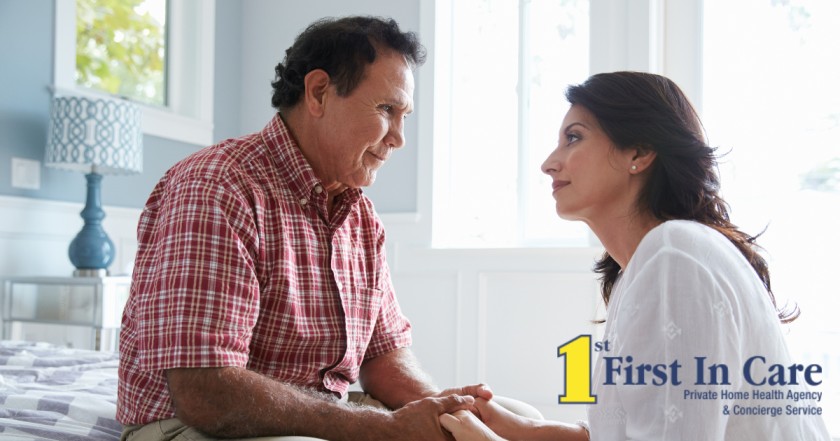 A daughter who is caregiving for her dad who has Alzheimer’s disease, lovingly holds his hands.