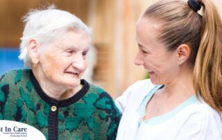 A professional caregiver compassionately hugs a senior client.