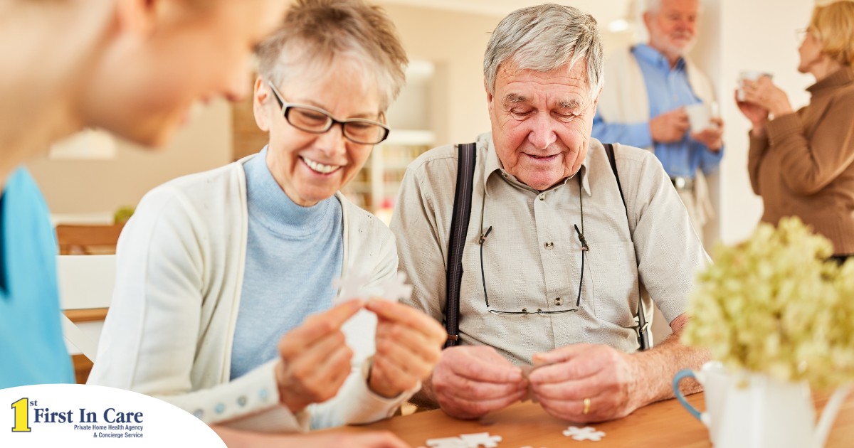 An older couple works on a puzzle with a caregiver, representing the kind of activity that helps those with dementia and also representing Alzheimer’s and Brain Awareness Month.