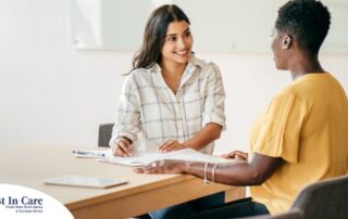 A woman happily interviews another woman, representing how well caregiver interviews can go when prepared.