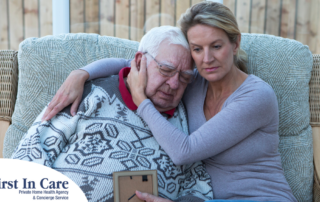 Adult daughter comforts her elderly father after the death of a loved one